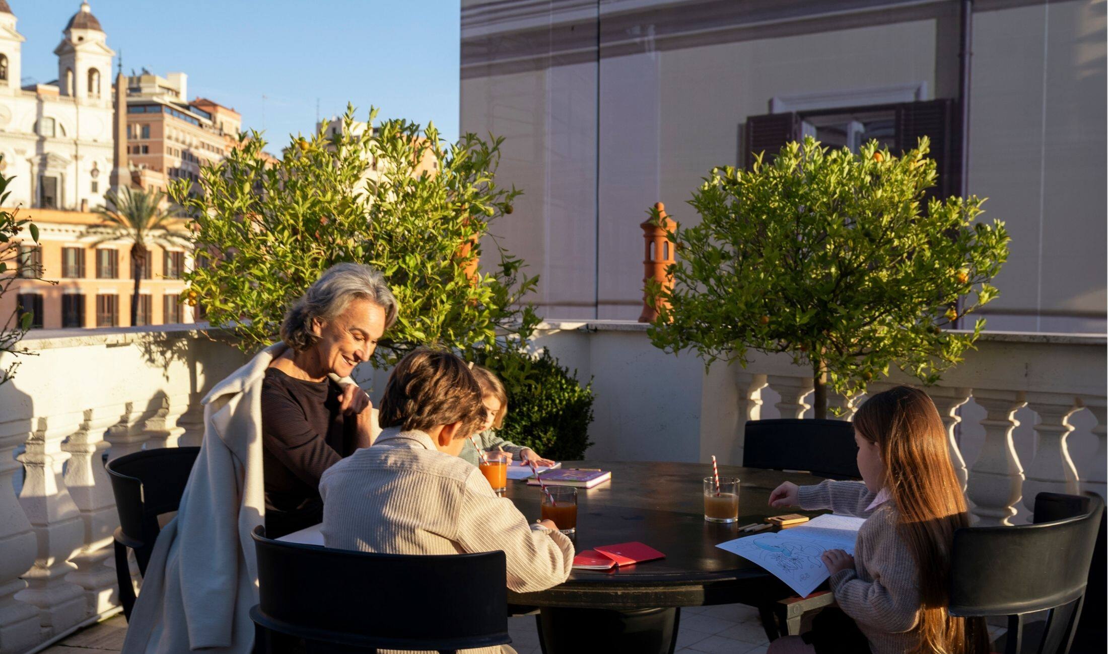 A Family with Kids enjoy a sunny afternoon on Rocco Forte House's Terrace in Rome