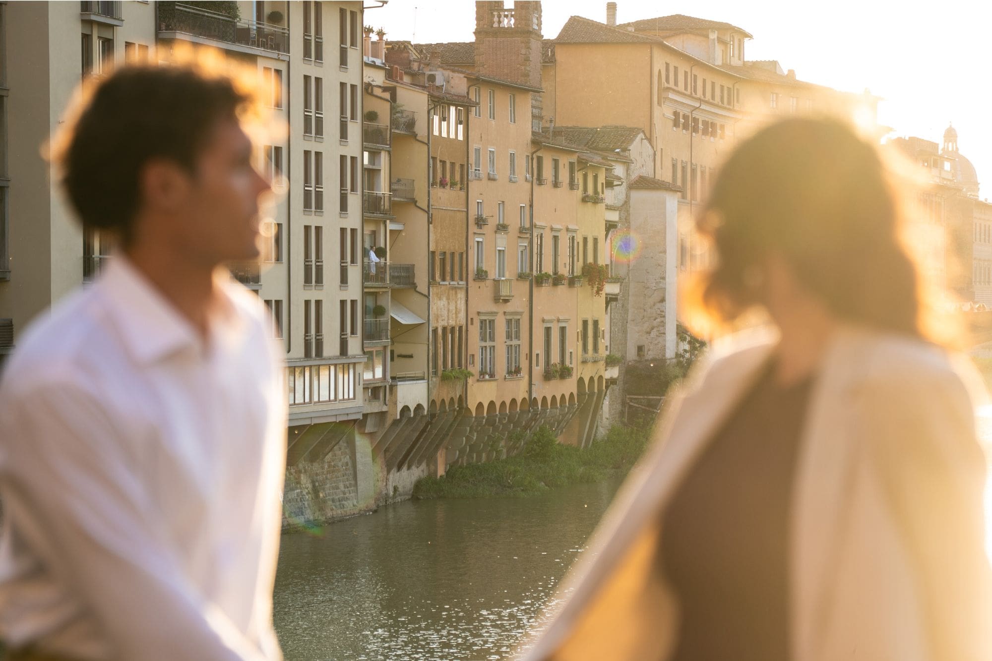 A couple enjoy sunset over Arno river in Florence, close to the Ponte Vecchio